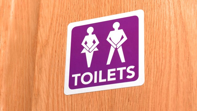 Gender neutral desperate for the toilet, illustrated on door sign 