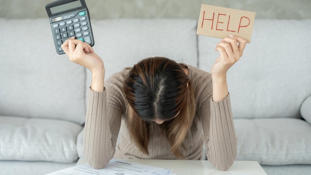 Stressed and headache asian woman with large bills or invoices no money to pay to expenses and credit card debt. shortage, Financial problems, mortgage, loan, bankruptcy, bankrupt, poor, empty wallet 