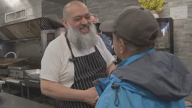 Celal Emanet speaks to a customer in the kitchen 